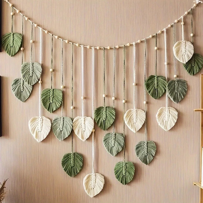 Plume en macramé suspendue abricot sur mur blanc