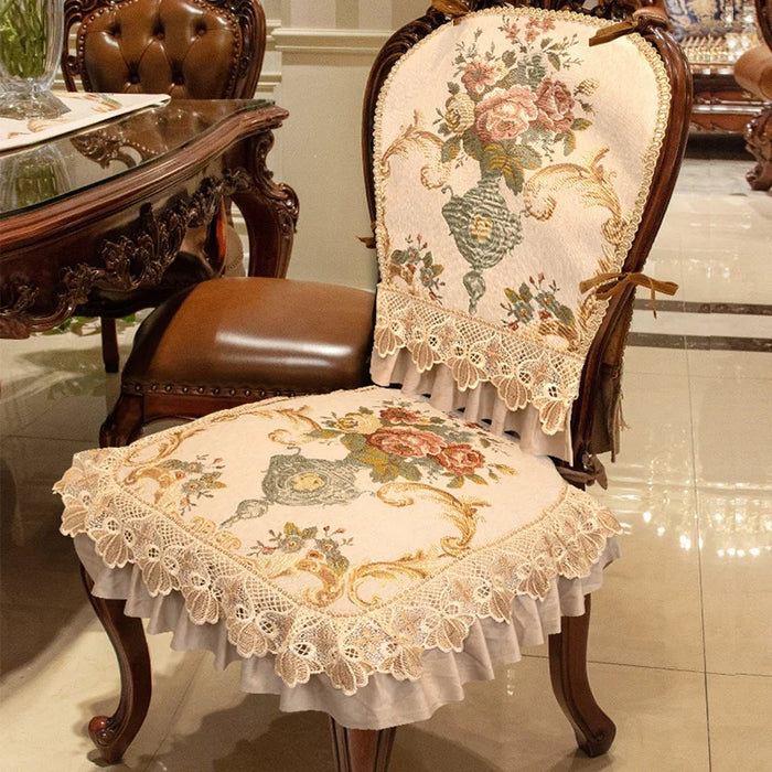 Chaise ancienne en bois foncé avec un rembourrage en tapisserie florale délicate, agrémentée de dentelles et de volants pour un style élégant et raffiné.
