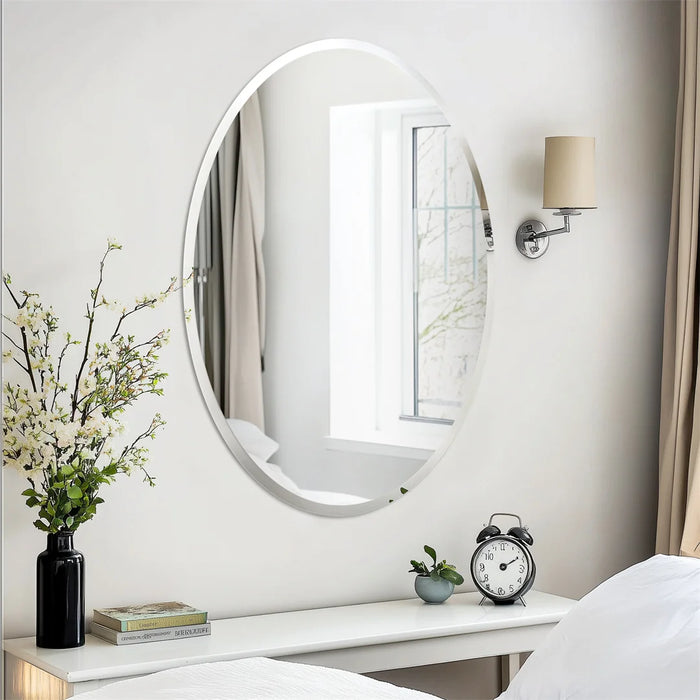 Le miroir ovale blanc incarne une décoration épurée et élégante dans cette chambre, rehaussée par un vase de fleurs fraîches et une horloge vintage posée sur la tablette blanche.