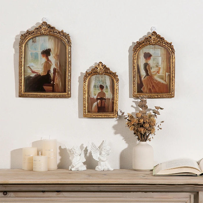 Cadre photo doré vintage en résine sur un mur blanc