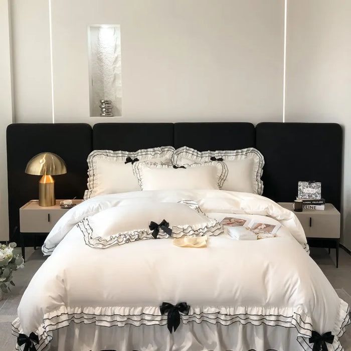 Housse de couette blanche à volants multicouches avec nœuds papillon sur lit