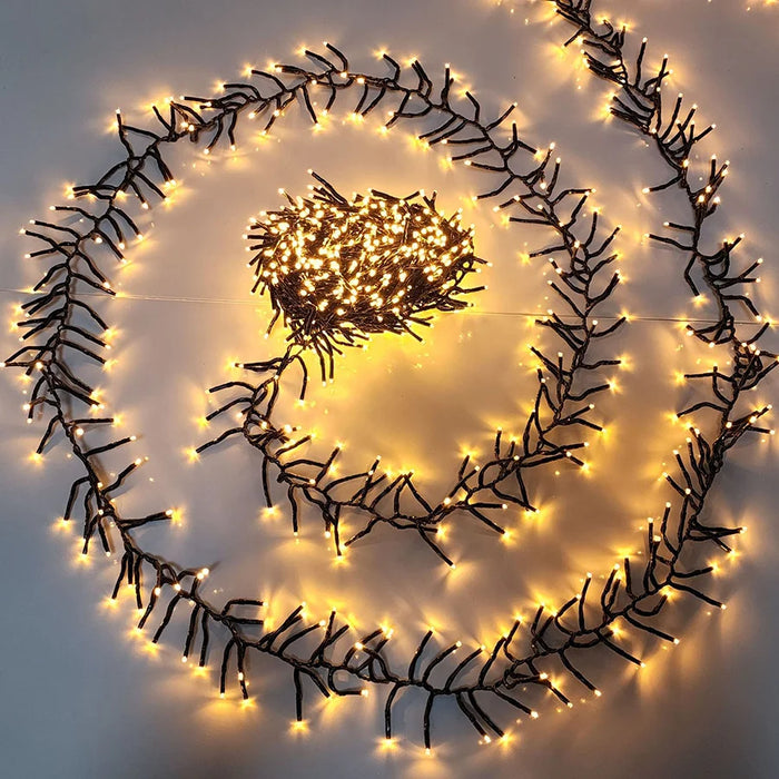 Guirlande lumineuse LED 30m 1500 lumières blanc chaud décorant un sapin de Noël
