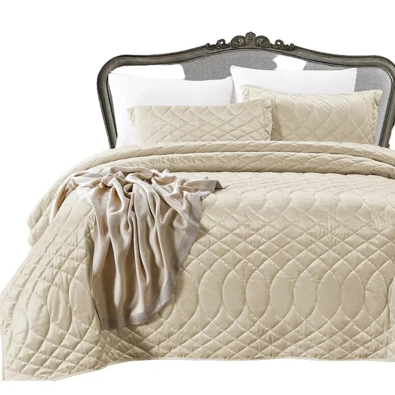 Couvre-lit matelassé beige sur un lit de chambre