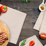 L'image montre une table en bois avec un plat de tomates, un linge de cuisine et des ustensiles de cuisine. Cela suggère un concept de cuisine ou de préparation de repas.