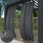 Image d'élégants rideaux gris foncé ondulant doucement sur une pergola en bois dans un jardin bien aménagé, offrant une zone d'ombre rafraîchissante et un design extérieur attrayant pour les arrière-cours.