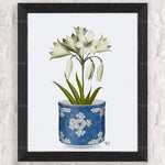 Une magnifique composition florale blanche dans un élégant pot décoratif bleu avec des fleurs stylisées.