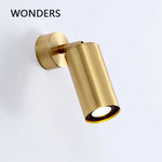 Applique murale LED en laiton doré style nordique sur un mur blanc