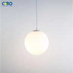 Lampe suspension verre blanc éclairée dans un intérieur moderne