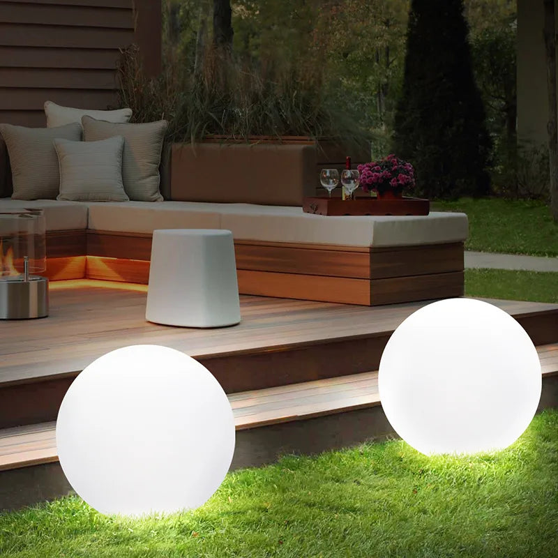 Boule lumineuse LED jaune posée sur une terrasse en bois