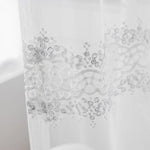 Rideau voilage blanc brodé dans un salon moderne