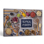 Variété de superaliments sains et naturels, épices, grains, noix et baies sur une table en bois avec un tableau noir affichant le texte "SUPER FOODS".