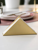Porte-serviettes or sur table de mariage avec nappe blanche