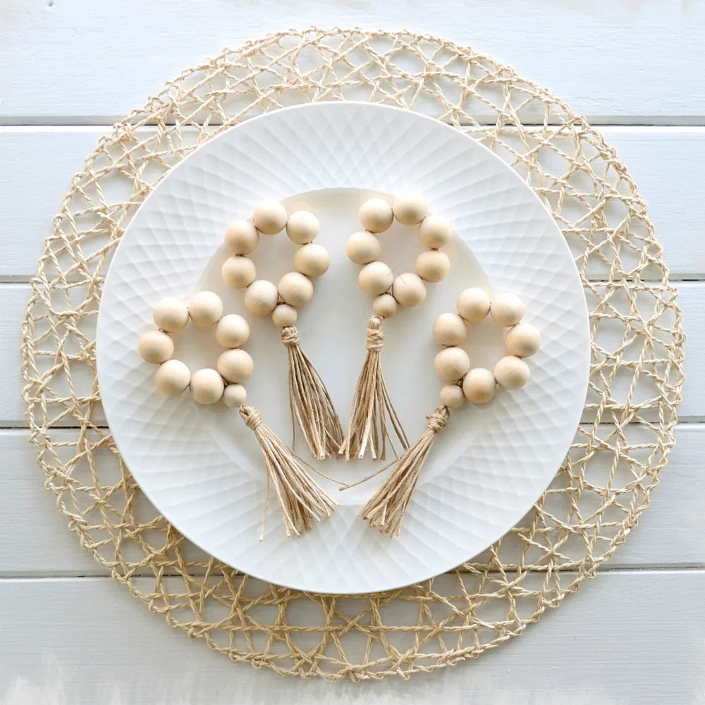 Détail des perles en bois et pompons en jute des anneaux de serviette