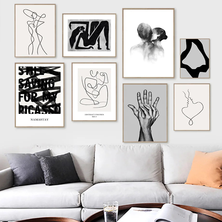 Galerie murale moderne avec une collection d'estampes et d'illustrations en noir et blanc, créant une ambiance artistique et épurée dans un intérieur.