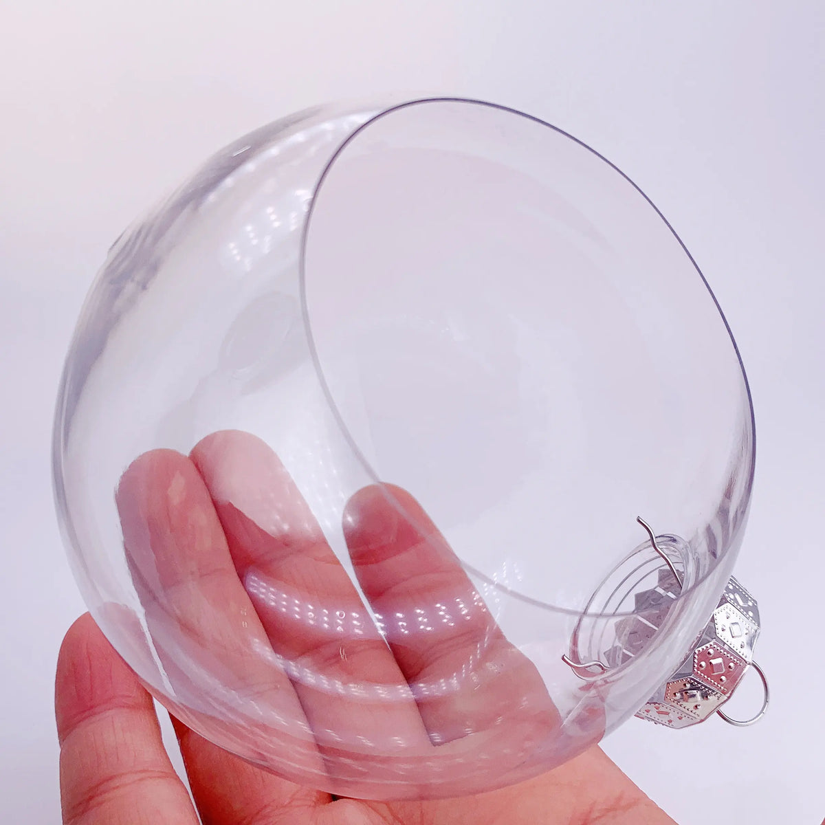 Enfant peignant une boule de Noël transparente en activité créative