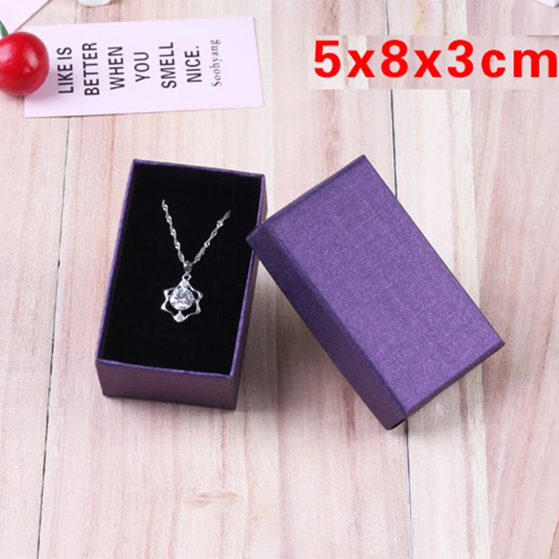 Boîte cadeau violette ouverte avec bague