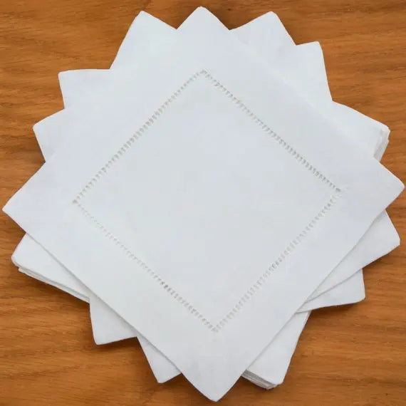 Pile de serviettes en papier blanches sur une surface en bois.