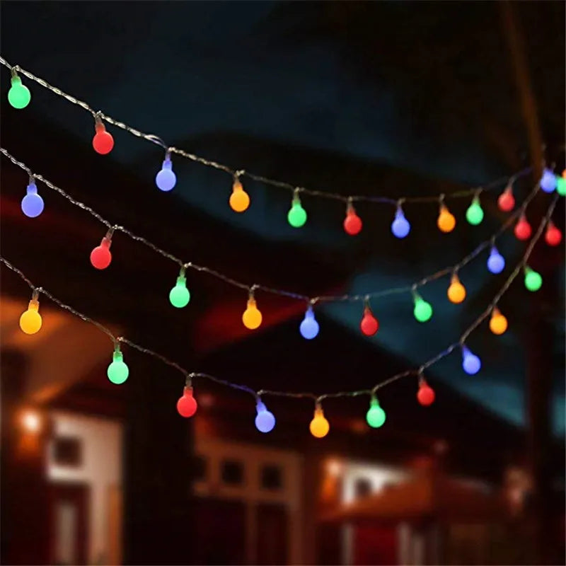 Guirlande lumineuse à boules LED multicolores 10m décorant un jardin