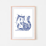 Une illustration de chat stylisée, avec des motifs floraux bleus et des étoiles, dans un cadre en bois clair.