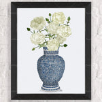 Un magnifique bouquet de fleurs blanches épanouies dans un vase en céramique bleu et blanc orné de motifs délicats.