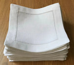 Serviettes de table blanches pliées avec bordure de points décorative.