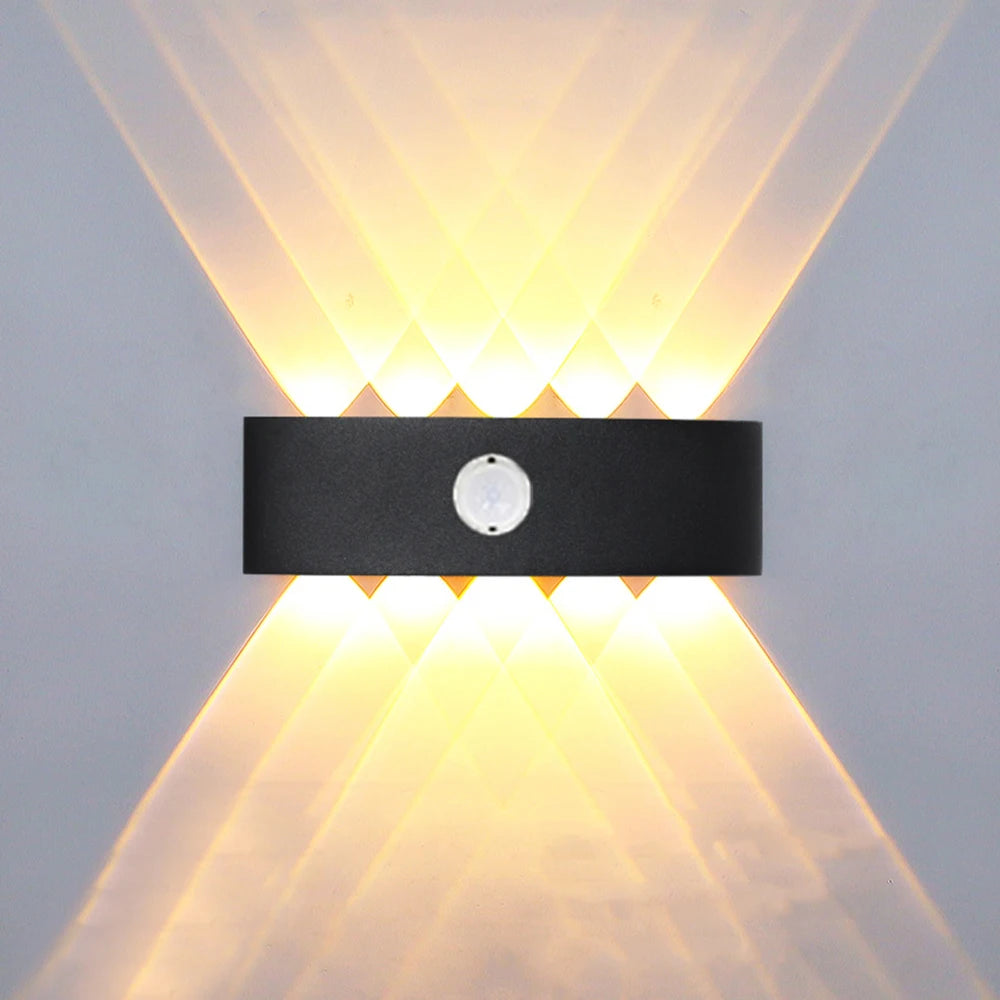 Applique murale extérieure LED noire avec détecteur de mouvement sur un mur de jardin