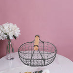 Panier métal rétro rempli de fruits sur une table en bois