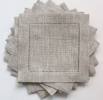Serviettes de table gris clair en lin avec une bordure décorative ajourée.