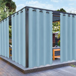Vue d'une pergola moderne habillée de rideaux imperméables bleu ciel, parfaits pour protéger du soleil et du vent tout en créant une ambiance élégante.