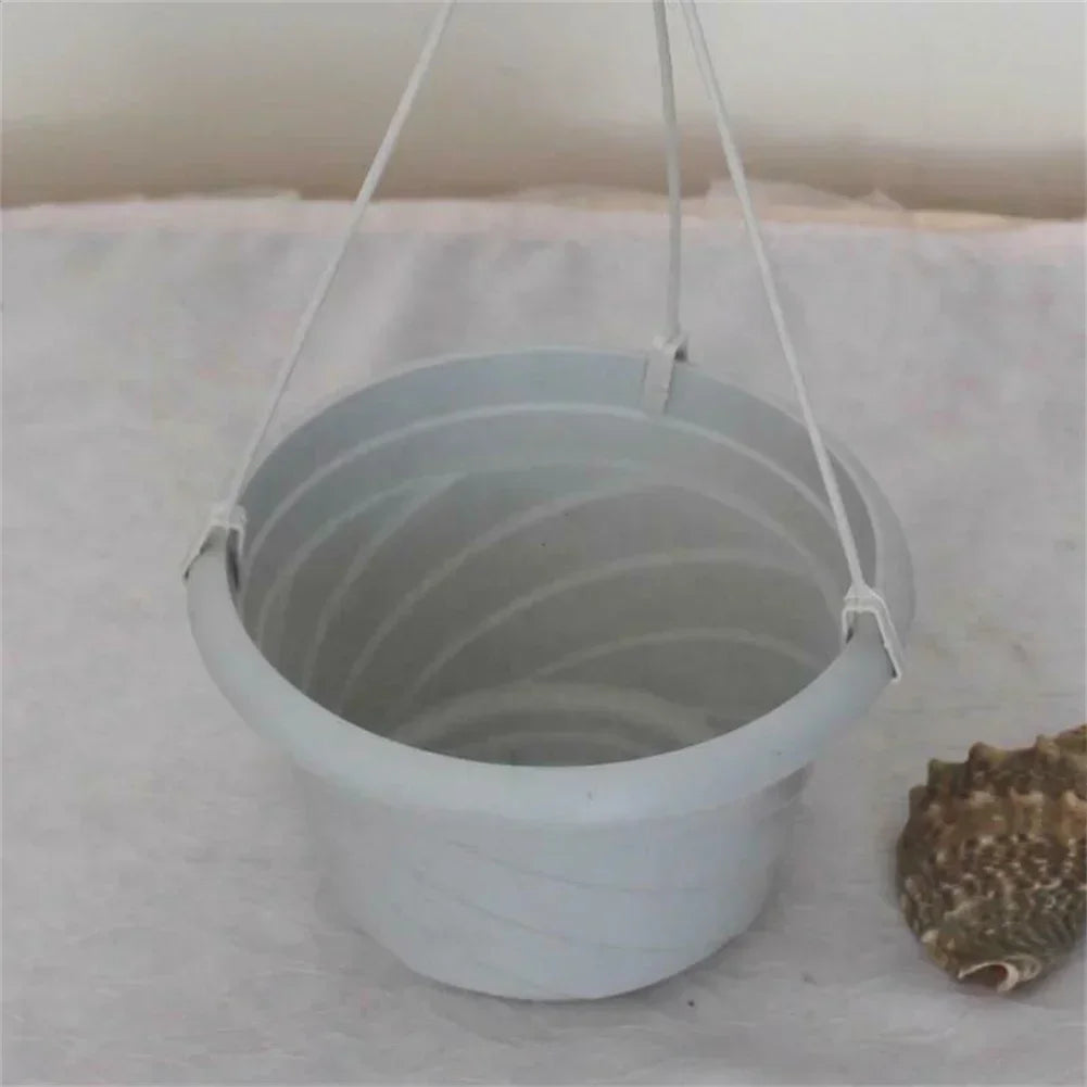 Composition de plusieurs porte-plantes muraux sur un mur de balcon