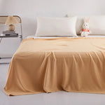 Une chambre à coucher confortable avec des draps beiges et un lapin en peluche sur le lit.