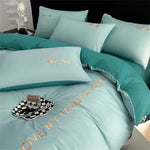 Parure de lit bleue disposée sur un lit moderne