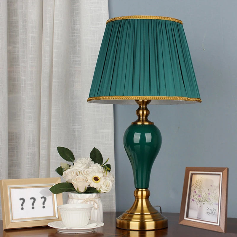 Lampe de chevet verte en céramique avec abat-jour blanc sur table de nuit