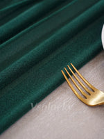 Chemin de table vert foncé avec assiettes blanches