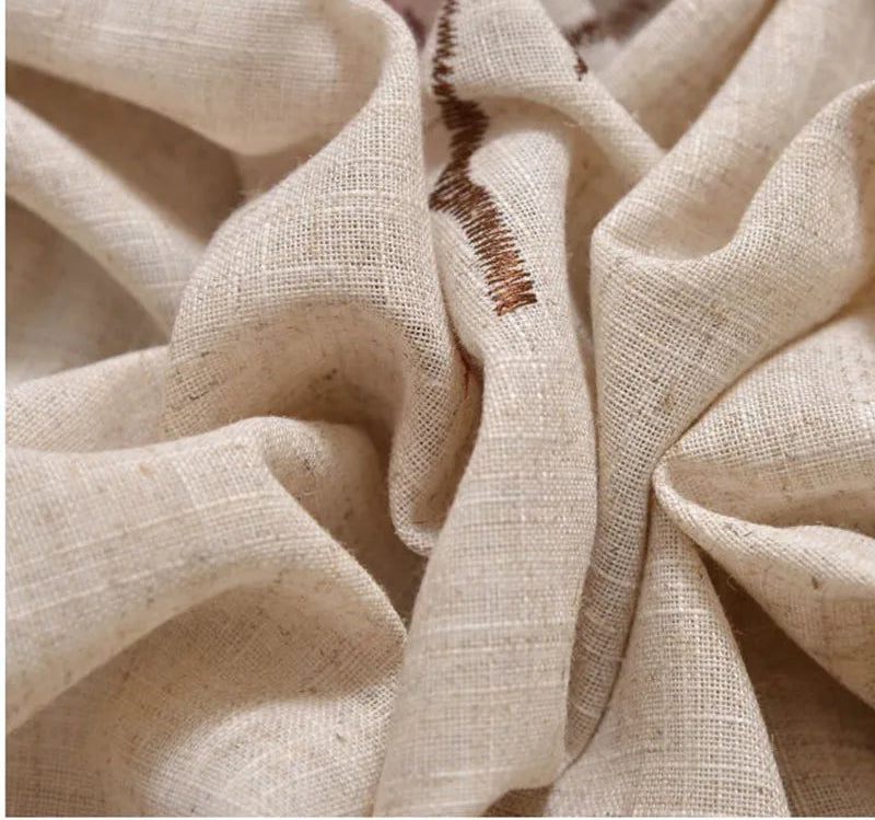 Gros plan sur un tissu beige avec un motif brodé marron, parfait pour des projets de couture ou de décoration intérieure raffinée. Lumineux, élégant et subtil, ce tissu ajoute une touche naturelle et authentique à tout espace de vie.