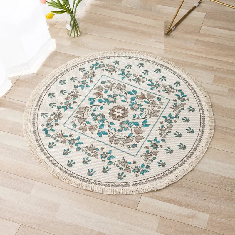 Tapis rond décoratif avec motifs floraux et feuillages en tons verts et beiges, posé sur un plancher en bois clair.