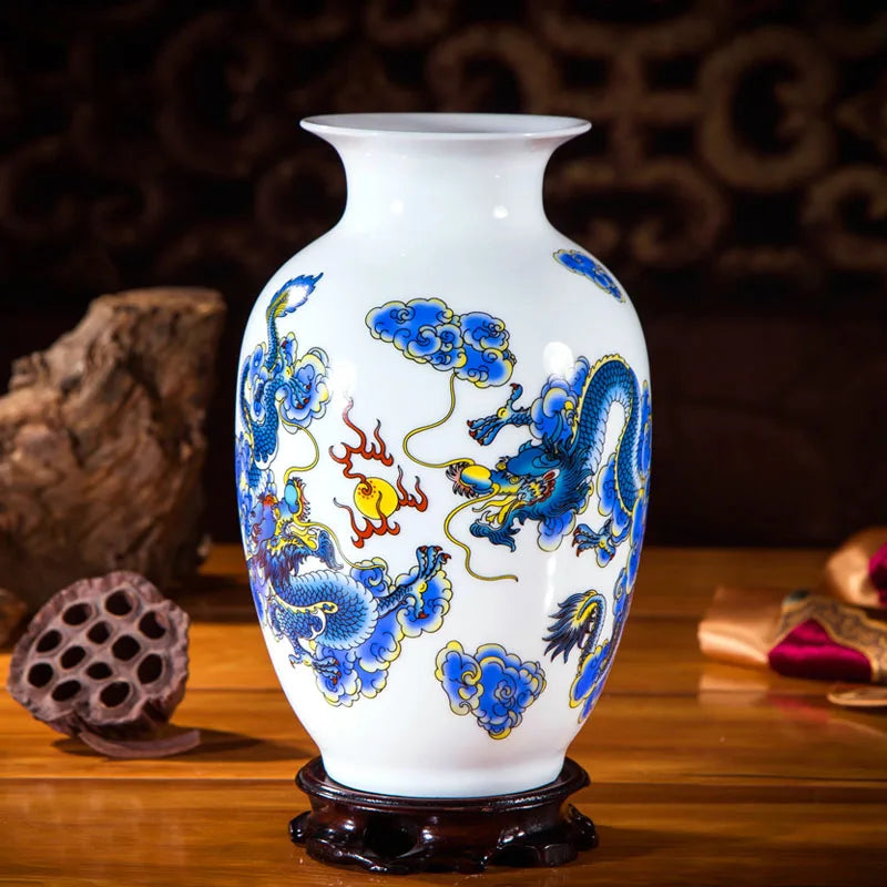 Un vase en porcelaine blanche décoré de motifs de dragons bleus et jaunes, avec une base en bois sombre.