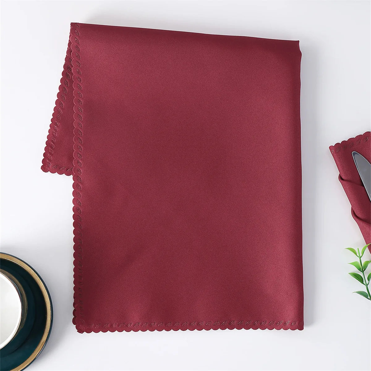 Un mouchoir en tissu de couleur bordeaux plié sur une surface blanche.