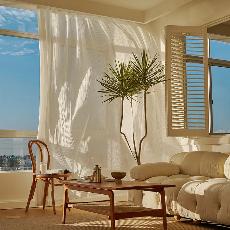 Des rideaux de luxe en textile, aux nuances variées de beige et blanc, apportant une touche de raffinement à l'intérieur d'une maison. Ce traitement de fenêtre élégant est parfaitement assorti au mobilier et à la décoration intérieure du salon, avec un éclairage doux qui se réfléchit sur le plancher en bois. L'image met en évidence l'harmonie entre les rideaux, le design d'intérieur et les autres éléments tels que le sol et l'éclairage, offrant une idée inspirante pour l'aménagement de votre espace de vie.