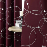 Zoom sur le tissu bordeaux à motifs blancs des rideaux, mettant en valeur la texture douce et la qualité du tissu.
