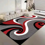 Un tapis rouge et gris avec des motifs de spirales et de rayures, placé dans un intérieur moderne et minimaliste avec un canapé blanc.