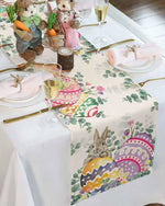 Un élégant service de table de Pâques avec des décorations fleuries, des verres à vin et des figurines de lapins mignons créant une atmosphère chaleureuse et festive.