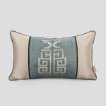 Coussin décoratif rectangulaire en tons de gris et beige avec un motif géométrique complexe.