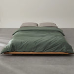 Parure de lit vert olive en lyocell et bambou sur un lit