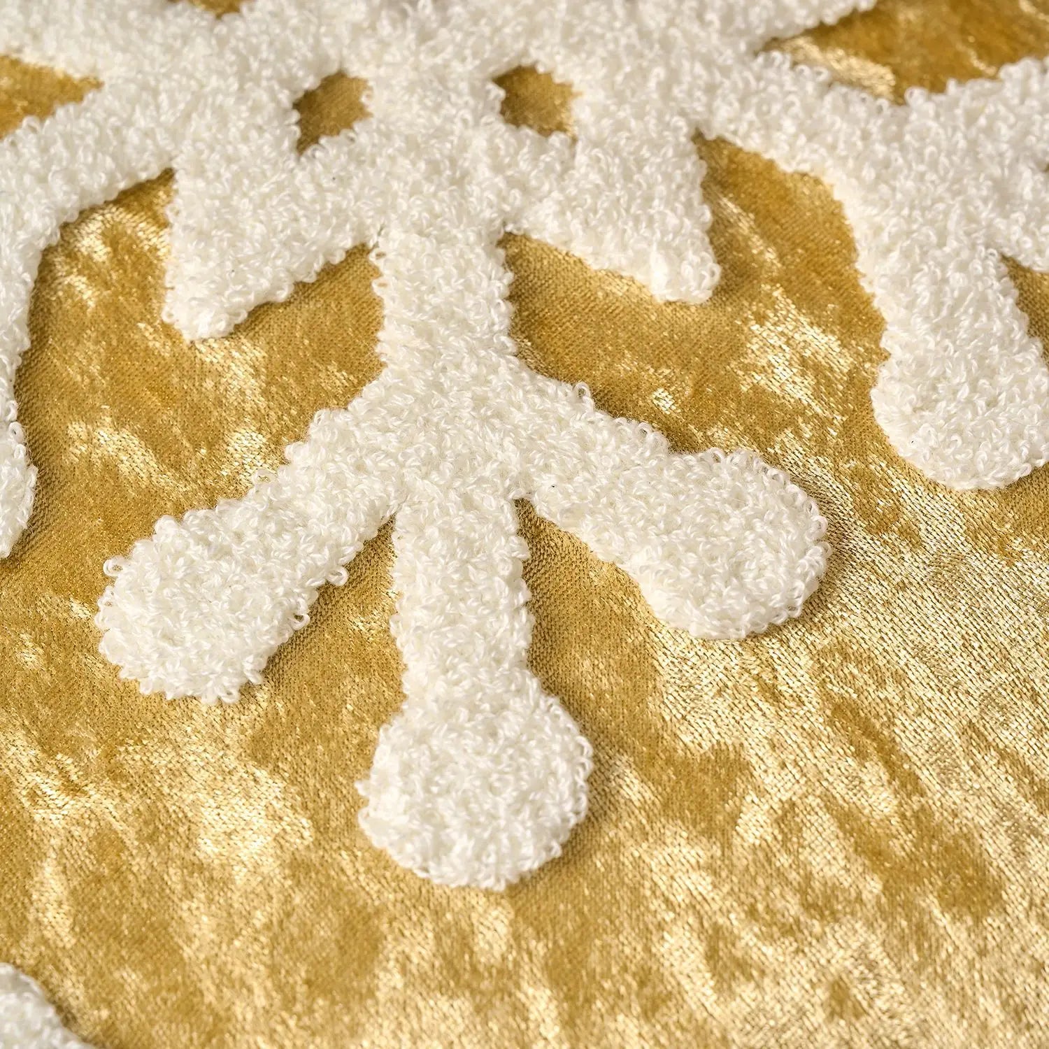 Des éléments dorés et texturés se mêlent dans un motif harmonieux sur un fond blanc.