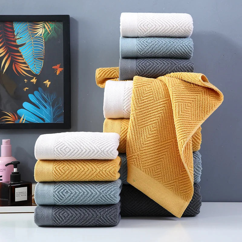 Une pile de serviettes de bain moelleuses et colorées, accompagnées d'un cadre décoratif avec des motifs tropicaux, créant une ambiance chaleureuse et accueillante dans la salle de bain.