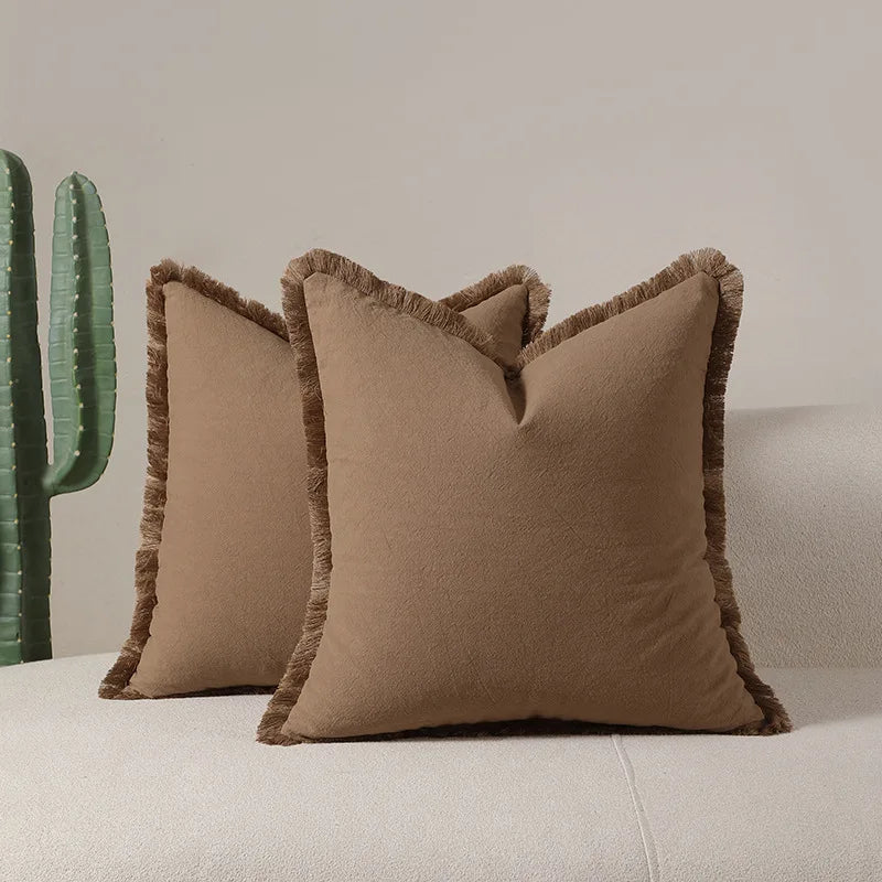 Des coussins beiges moelleux avec des bordures ornées apportent une touche de confort et d'élégance à l'espace.