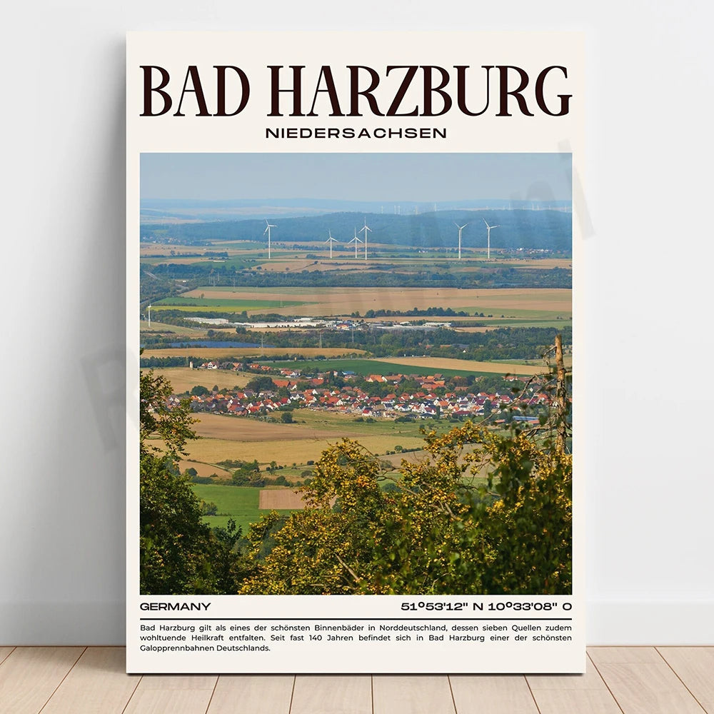 Un paysage de campagne vallonné avec des maisons colorées, des champs et des éoliennes dans la distance, offrant une vue panoramique sur la ville de Bad Harzburg en Allemagne.