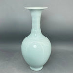 Vase décoratif vintage en porcelaine blanche lisse et brillante avec une forme élégante et épurée.