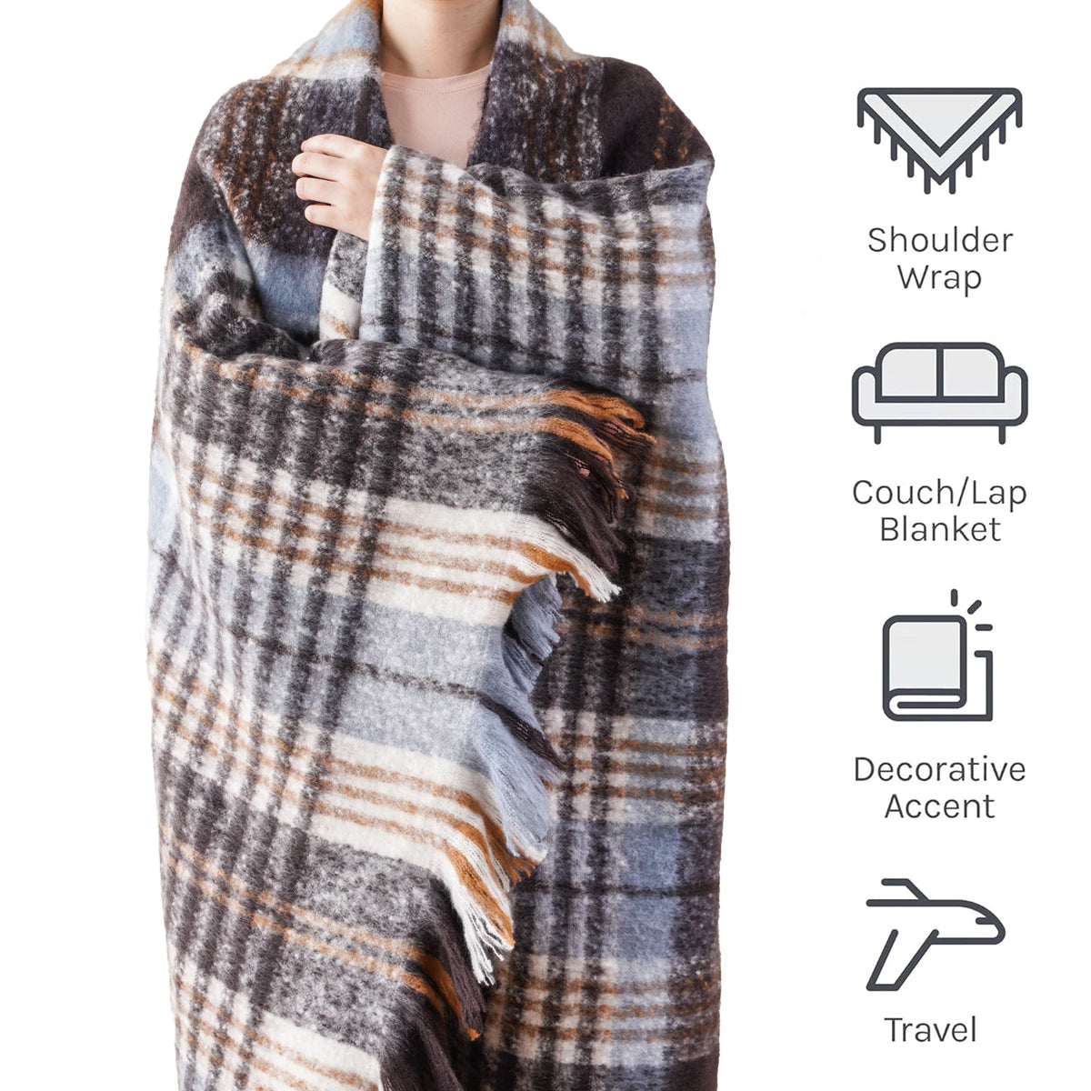 Une femme enveloppée dans une couverture à carreaux grise et beige qui peut être utilisée comme un châle pour les épaules, une couverture pour le canapé ou le lit, ainsi qu'un accessoire de voyage.